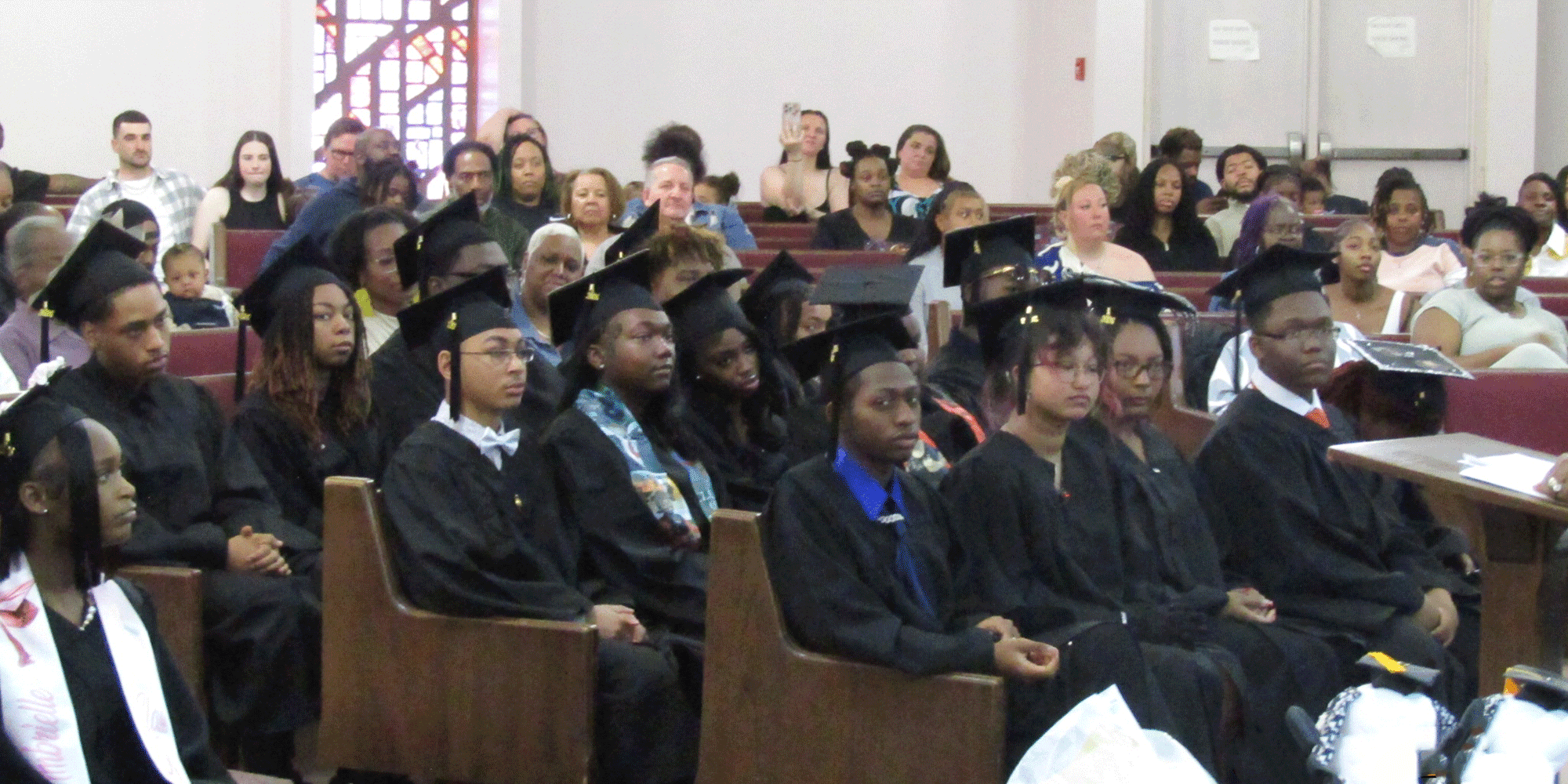 Graduates and guests seated in an auditorium.